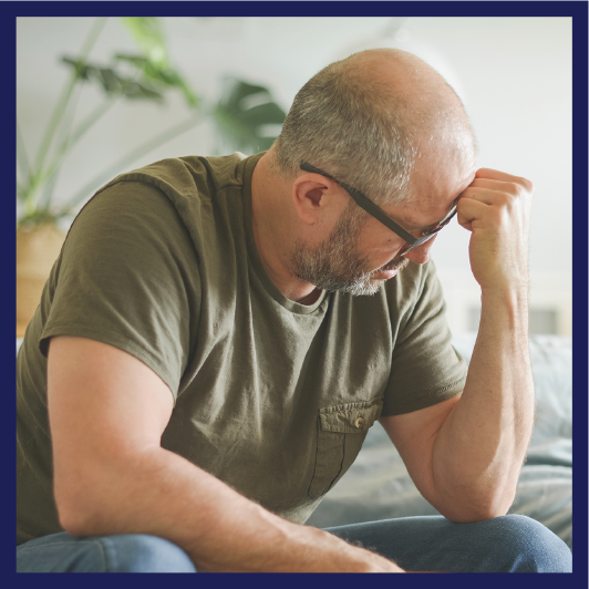 A person looking upset and holding their hand to their forehead.