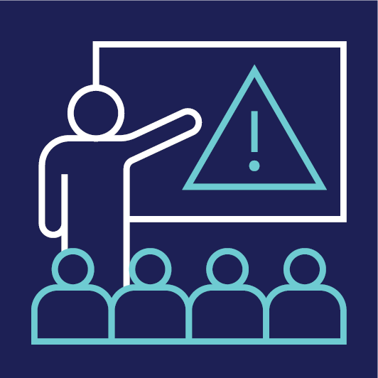 A person training people. They are standing in front of a whiteboard and pointing to a problem icon.
