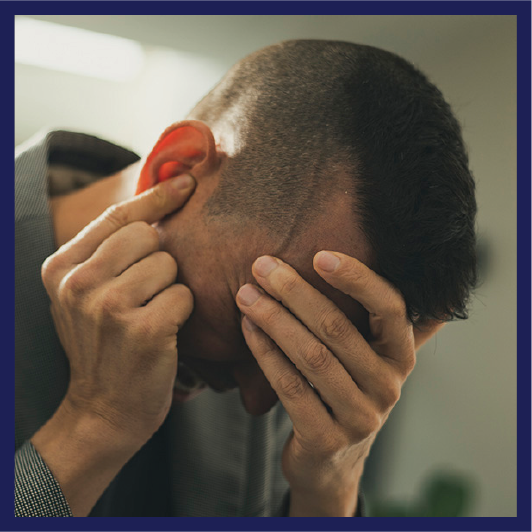 A person looking very sad with their head in their hands.