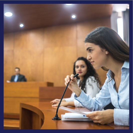 A person speaking into a microphone iin a courtroom.